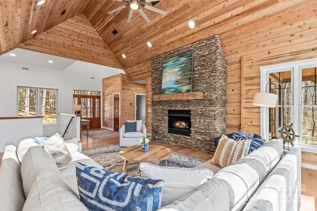 a living room with furniture a flat screen tv and a fireplace