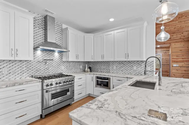 a kitchen with granite countertop a stove sink and cabinets