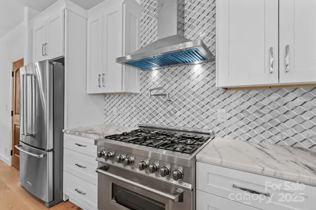 a kitchen with stainless steel appliances granite countertop a stove and a refrigerator