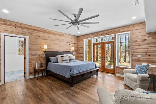 a spacious bedroom with a bed and glass walk in closet