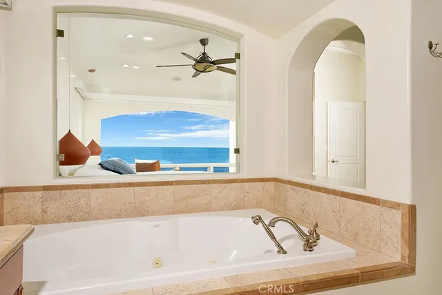 a bathroom with a tub and mirror