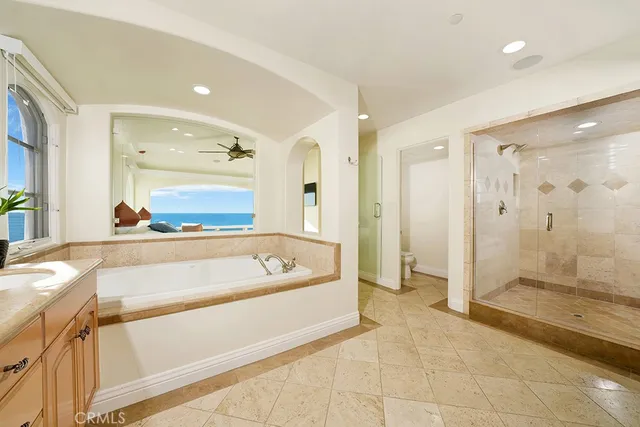a spacious bathroom with a tub shower and mirror