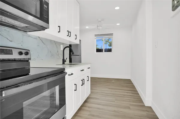 a kitchen with granite countertop a sink and a stove top oven