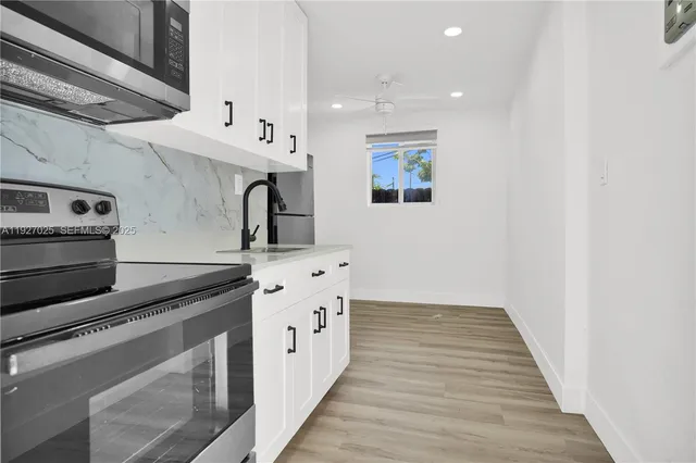 a kitchen with granite countertop a sink and a stove top oven