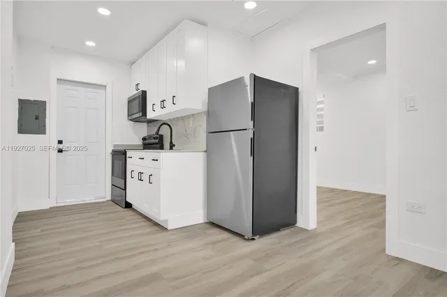 a kitchen with stainless steel appliances a refrigerator sink and cabinets
