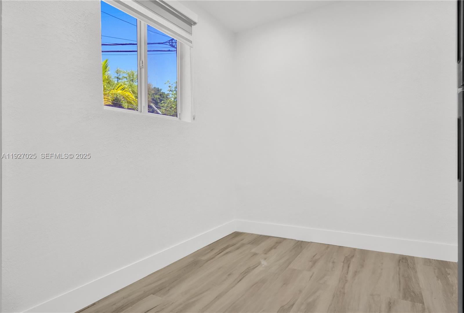 210 Beacom Boulevard, Unit B Miami, FL 33135 - Photo 5 of 9 a view of an empty room with wooden floor and window