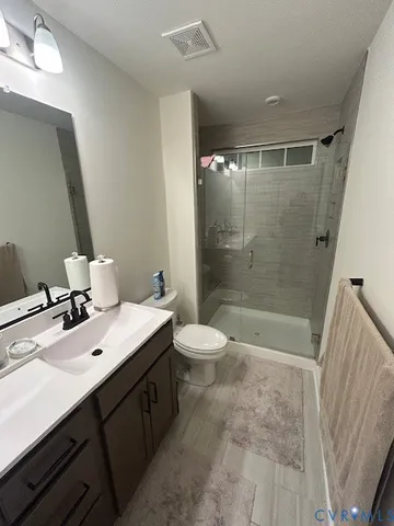 a bathroom with a double vanity sink toilet mirror and shower