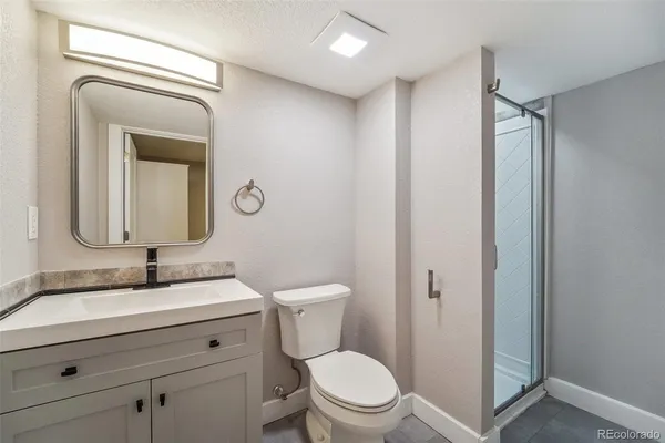 a bathroom with a toilet sink vanity and mirror