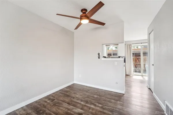 a view of a kitchen with wooden floor and a ceiling fan