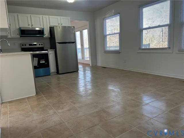 a kitchen with granite countertop a refrigerator and a stove top oven