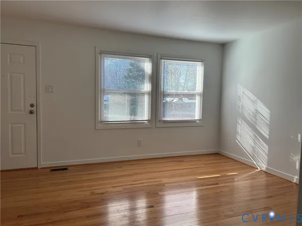 a view of a room with wooden floor and window