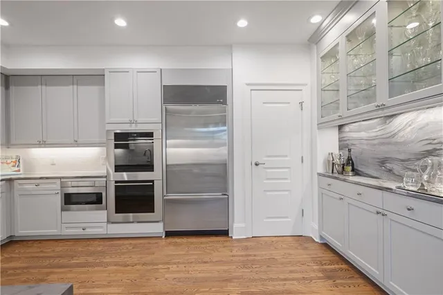 a kitchen with stainless steel appliances kitchen island granite countertop a refrigerator and a sink