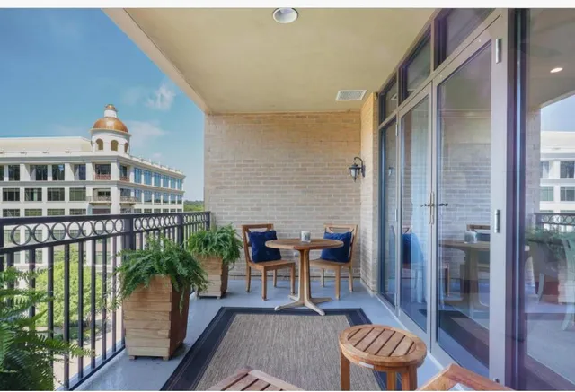 a balcony with chairs and with potted plants