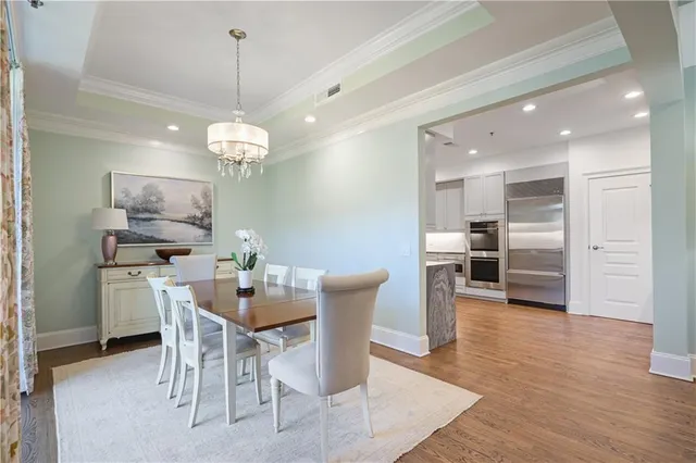 a dining room with furniture a chandelier and wooden floor