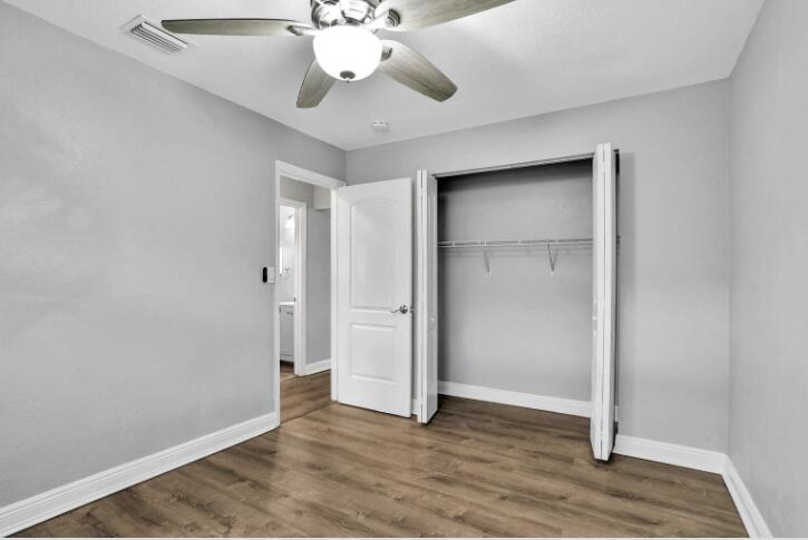 240 Southeast 9th Avenue, Unit 2 Pompano Beach, FL 33060 - Photo 14 of 17 an empty room with wooden floor fan and windows