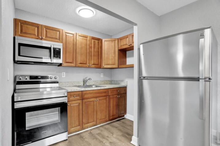 240 Southeast 9th Avenue, Unit 2 Pompano Beach, FL 33060 - Photo 2 of 17 a kitchen with stainless steel appliances granite countertop a refrigerator and a stove top oven
