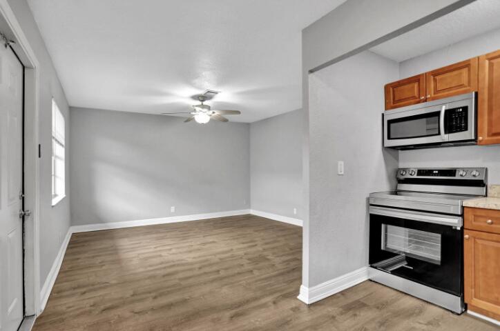 240 Southeast 9th Avenue, Unit 2 Pompano Beach, FL 33060 - Photo 3 of 17 a view of kitchen and empty room with wooden floor