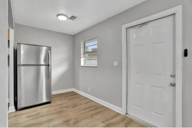 a view of empty room with wooden floor and closet