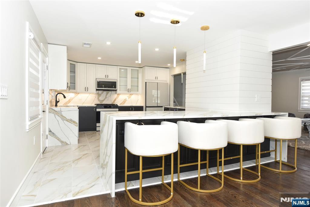 28 Overlook Road Saddle River, NJ 07458 - Photo 14 of 35 a kitchen with a dining table chairs sink and white cabinets