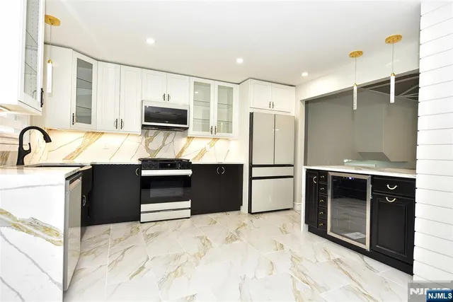 a kitchen with stainless steel appliances kitchen island granite countertop a refrigerator and a sink