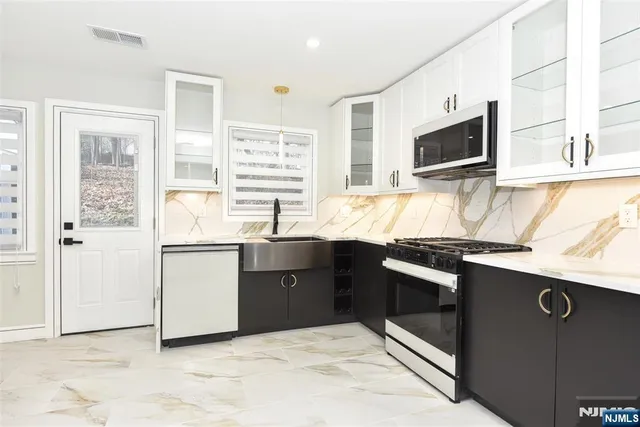 a kitchen with stainless steel appliances granite countertop a sink and a microwave