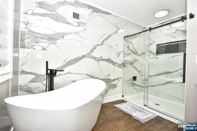 a white bath tub sitting next to a shower