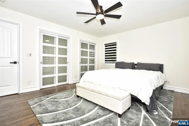 a large bed sitting in a bedroom next to a window and a chandelier