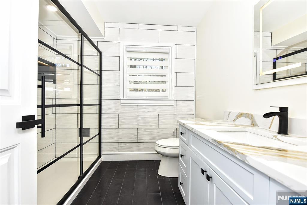 28 Overlook Road Saddle River, NJ 07458 - Photo 28 of 35 a bathroom with a granite countertop sink toilet a mirror and shower