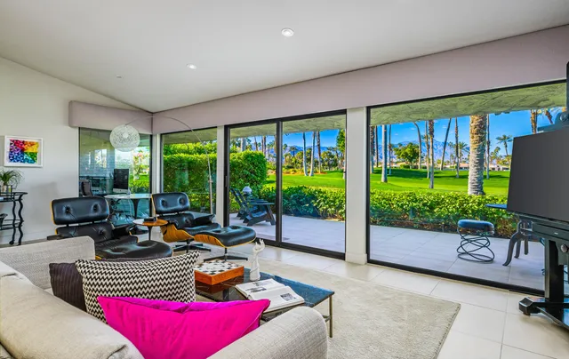 a living room with furniture large window and a fireplace