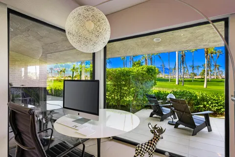 a view of a backyard with potted plants and a chair