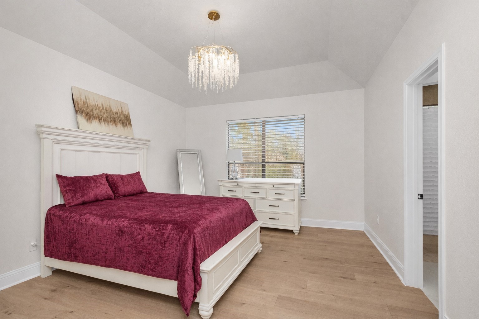 10004 Summer Ridge Lane Conroe, TX 77302 - Photo 34 of 50 a bedroom with a large bed and a chandelier