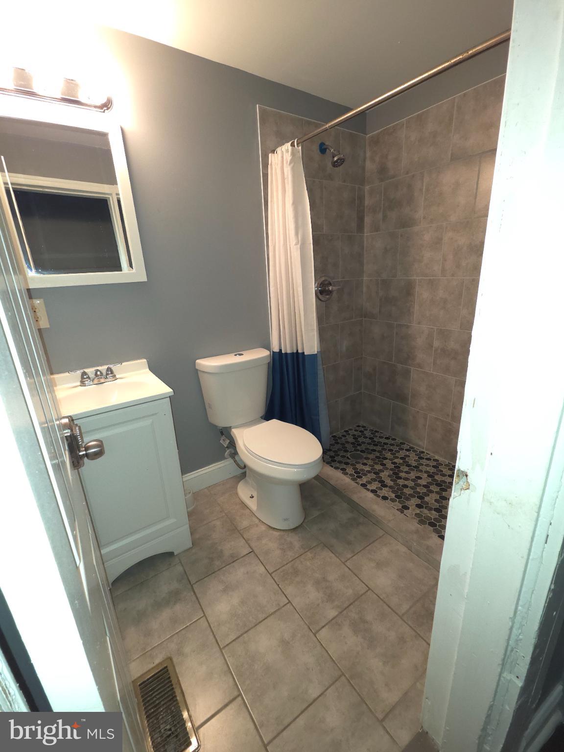 2617 East Preston Street Baltimore, MD 21213 - Photo 11 of 30 a bathroom with a sink a toilet a window and shower