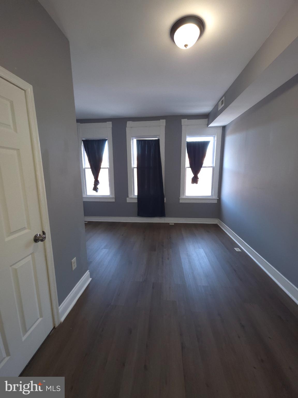 2617 East Preston Street Baltimore, MD 21213 - Photo 15 of 30 an empty room with wooden floor and windows