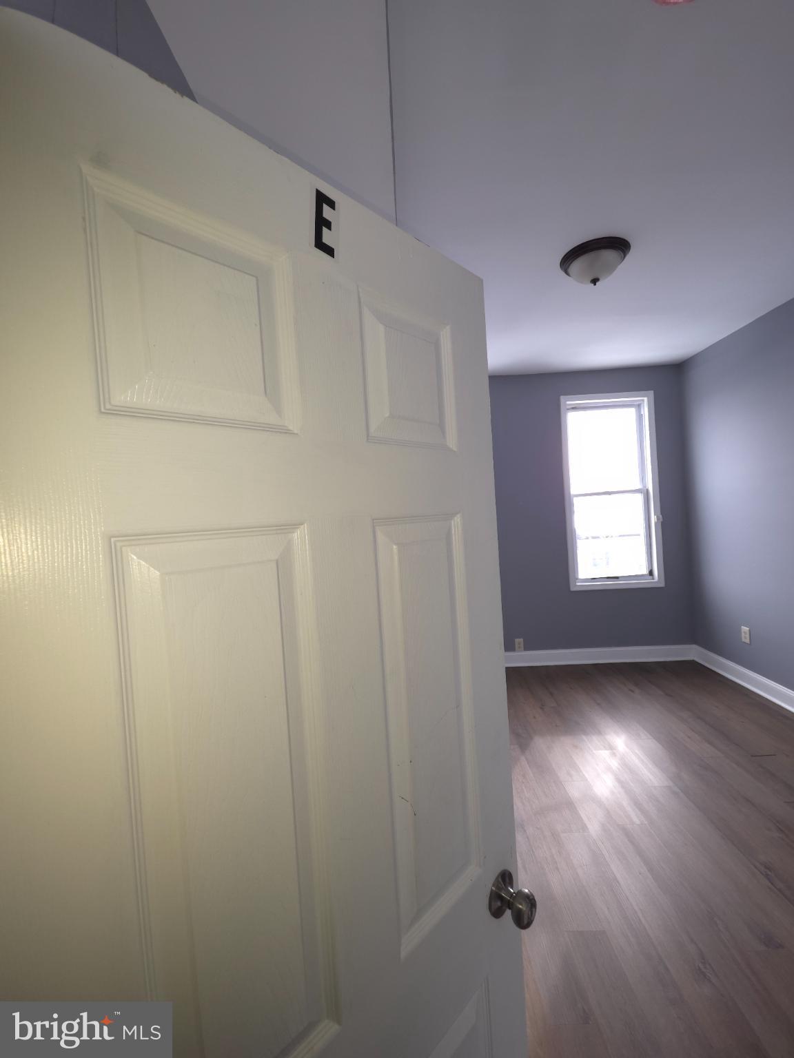 2617 East Preston Street Baltimore, MD 21213 - Photo 22 of 30 an empty room with wooden floor and windows