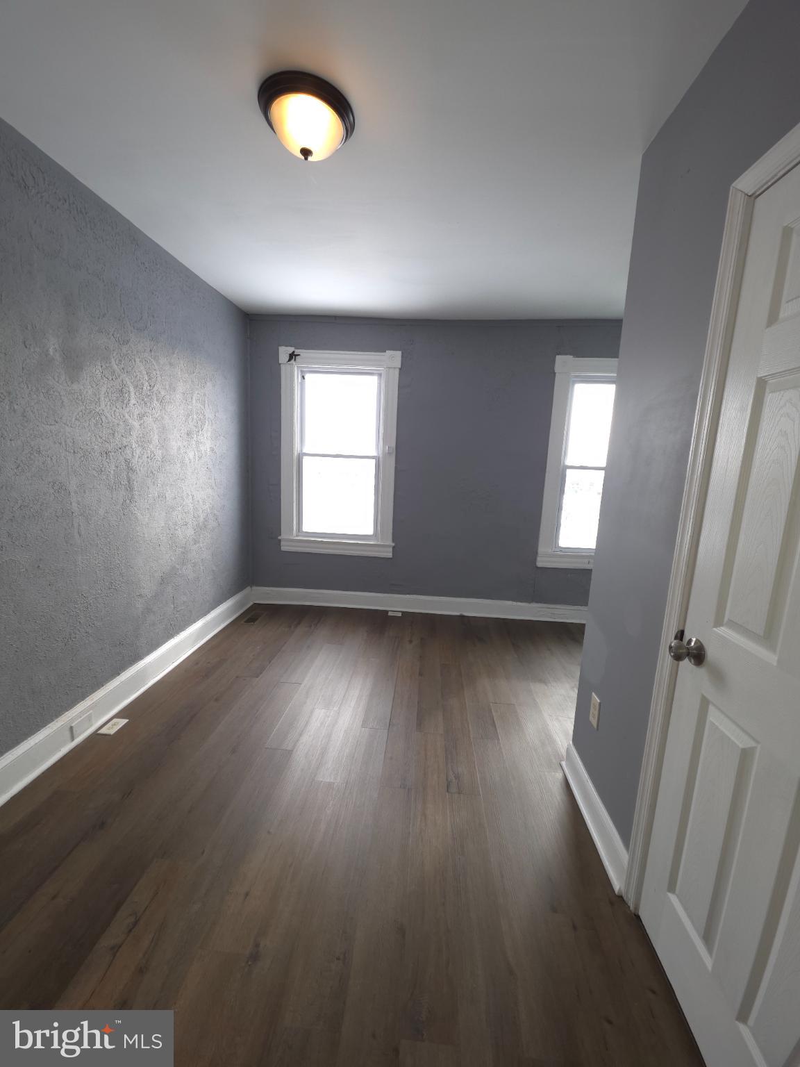 2617 East Preston Street Baltimore, MD 21213 - Photo 28 of 30 an empty room with wooden floor and windows
