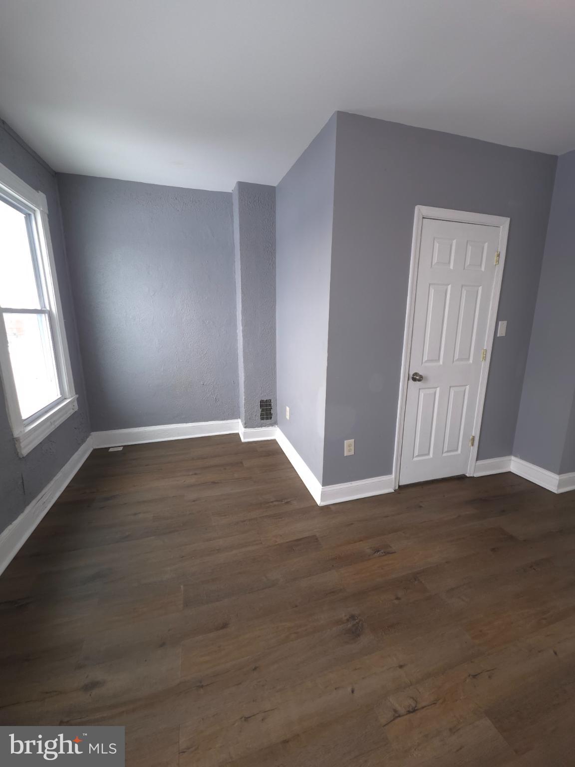 2617 East Preston Street Baltimore, MD 21213 - Photo 29 of 30 an empty room with wooden floor and windows