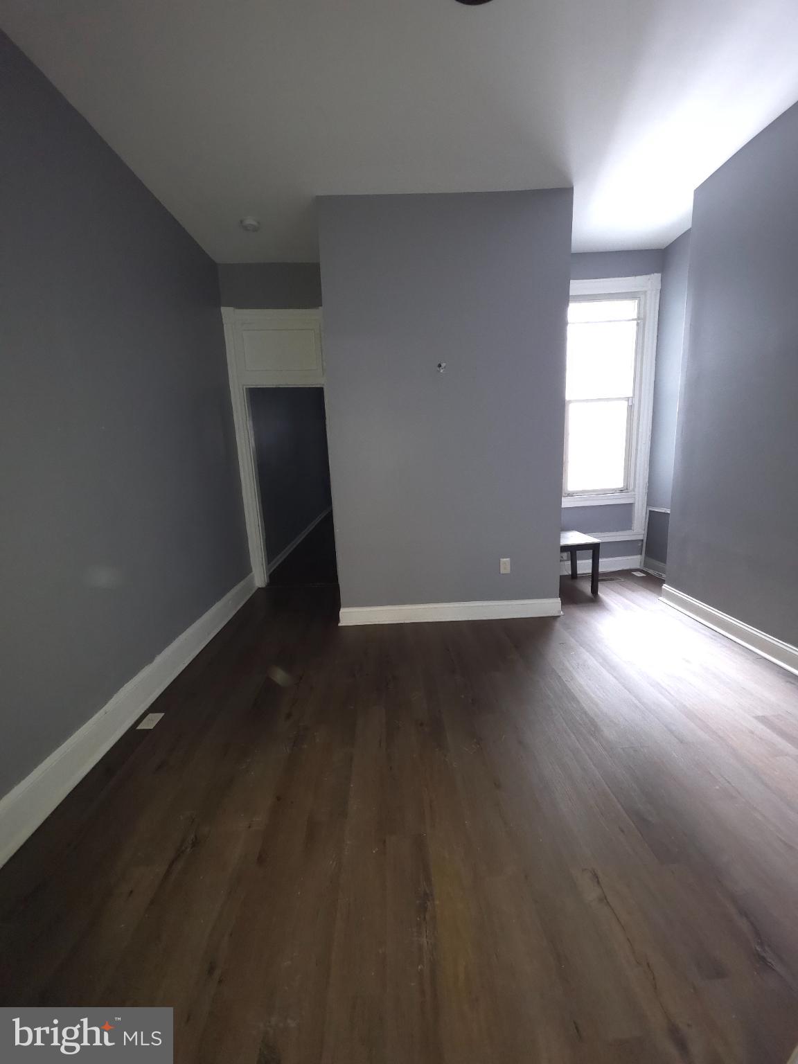 2617 East Preston Street Baltimore, MD 21213 - Photo 6 of 30 a view of a room with wooden floor and a window