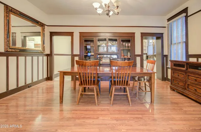 a dining room with furniture a chandelier and wooden floor