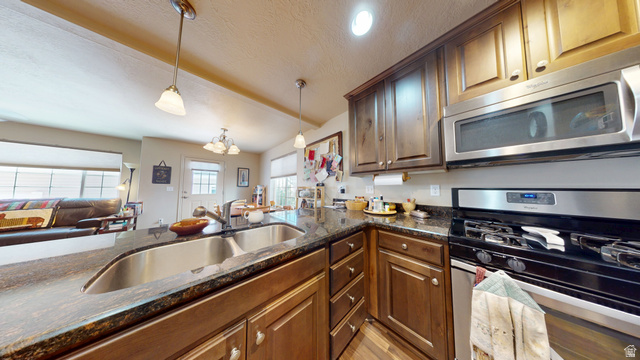 1674 Eastridge Road Price, UT 84501 - Photo 7 of 34 Kitchen featuring dark wood cabinetry, a double basin stainless steel sink, and dark granite countertops