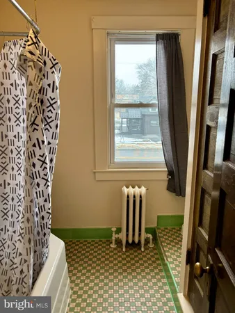 a bathroom with a sink a toilet a window and a shower