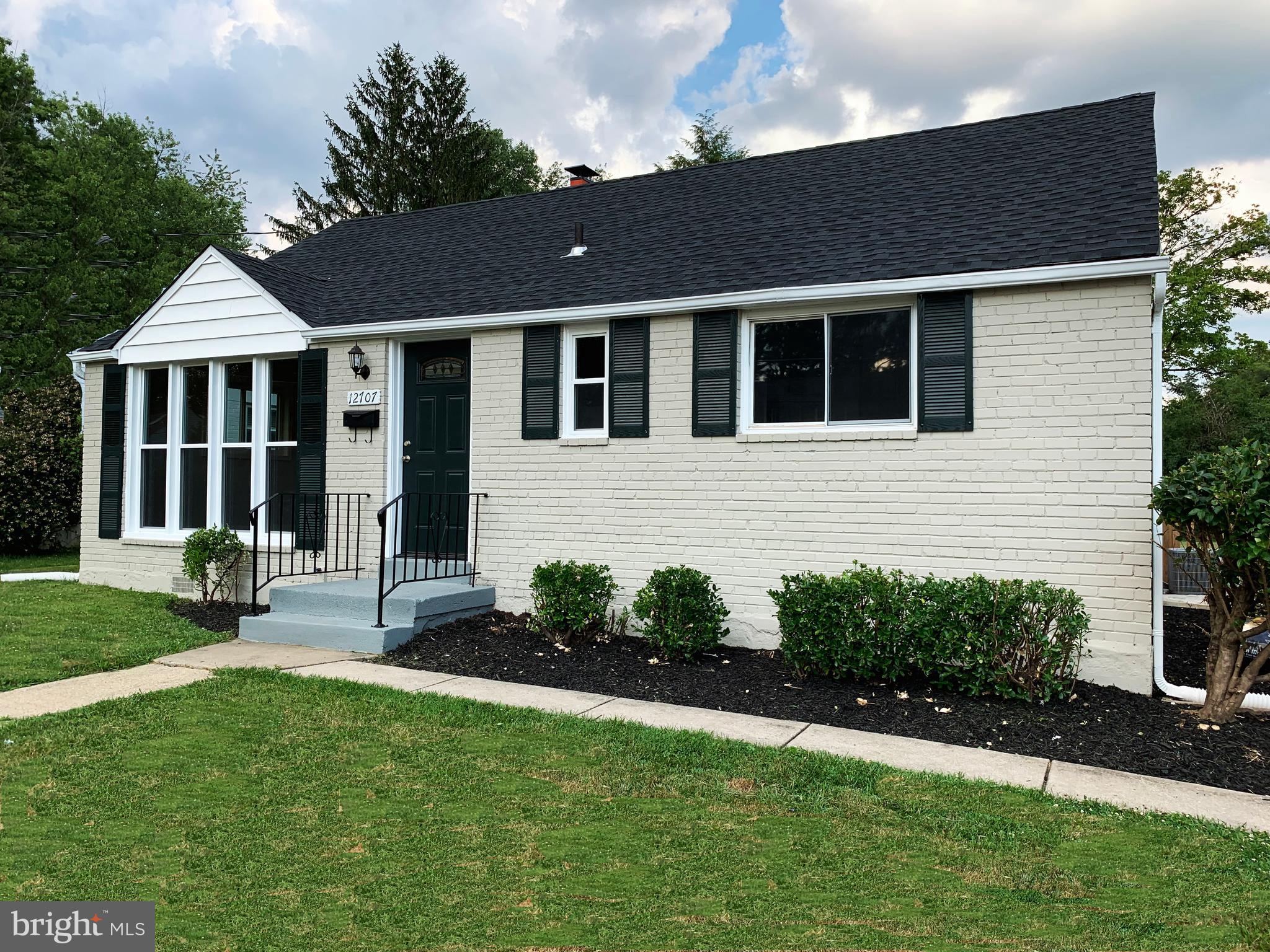 12707 Gould Road Silver Spring, MD 20906 - Photo 5 of 23 a front view of a house with a garden and yard