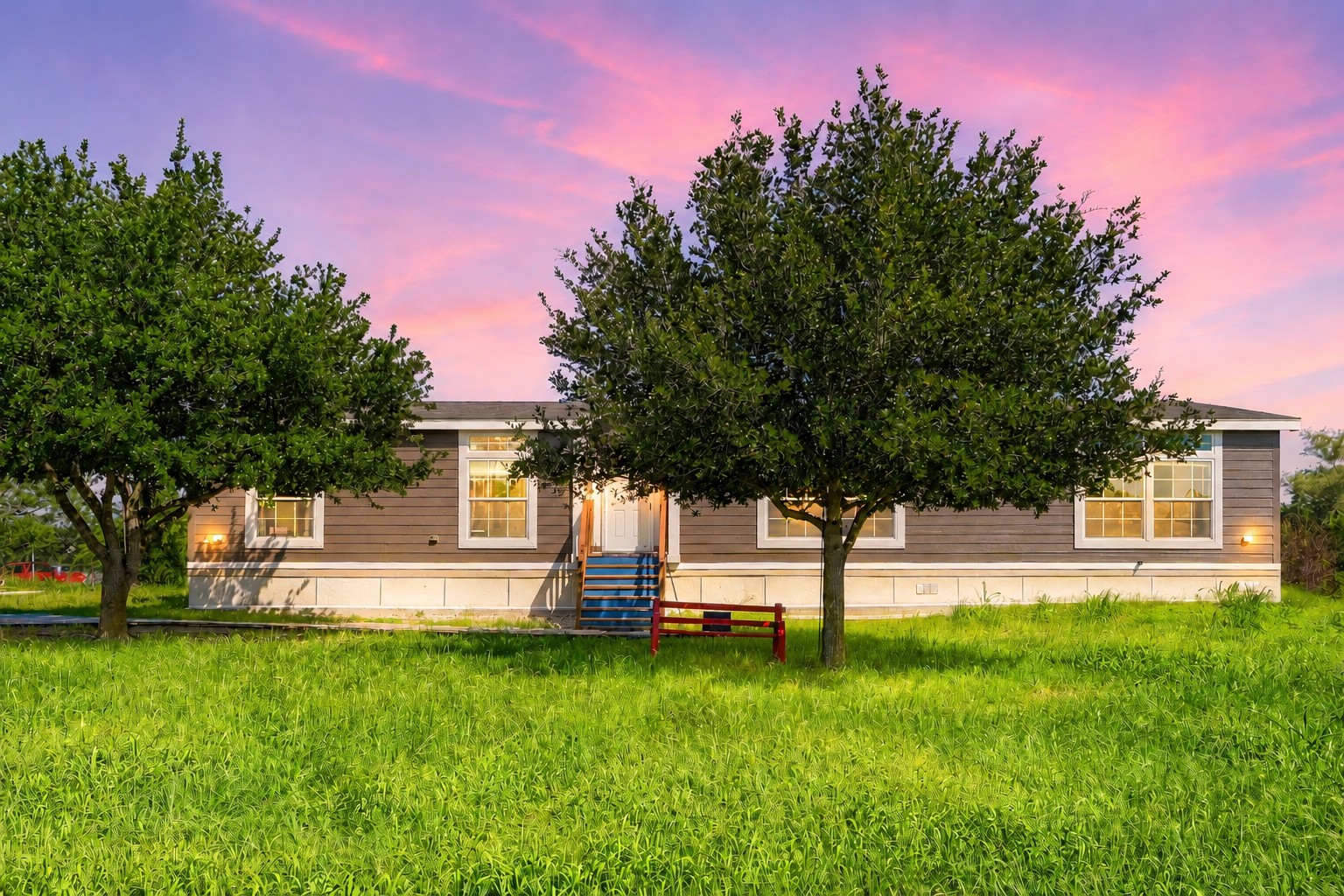 401 Graef Road Kyle, TX 78640 - Photo 2 of 30 A classic ranch-style residence nestled in a verdant landscape under a colorful sky.
