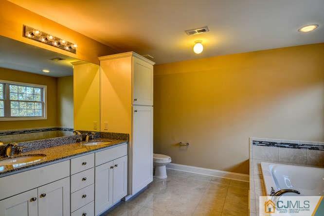 5 Homestead Road Edison, NJ 08820 - Photo 23 of 25 a spacious bathroom with a granite countertop sink and a mirror