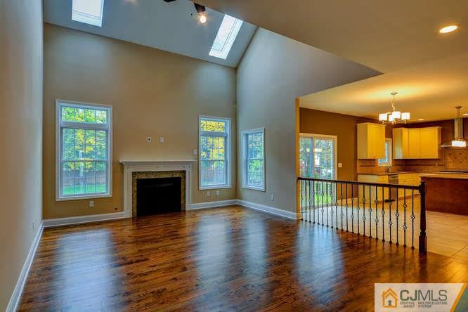 5 Homestead Road Edison, NJ 08820 - Photo 6 of 25 an empty room with wooden floor fireplace and windows