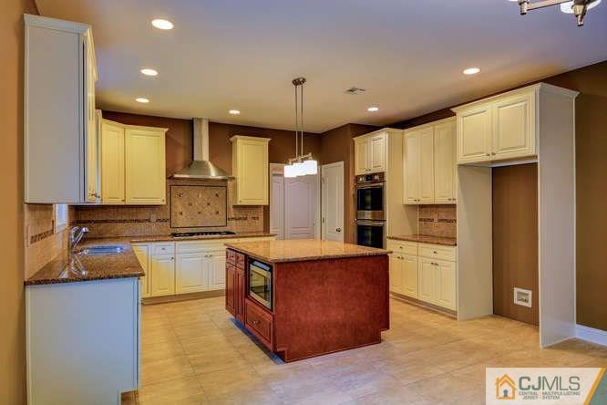5 Homestead Road Edison, NJ 08820 - Photo 10 of 25 a kitchen with stainless steel appliances granite countertop a stove top oven a sink dishwasher a refrigerator and a dining table cabinets