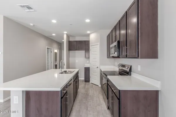 a kitchen with granite countertop a stove a sink and a microwave