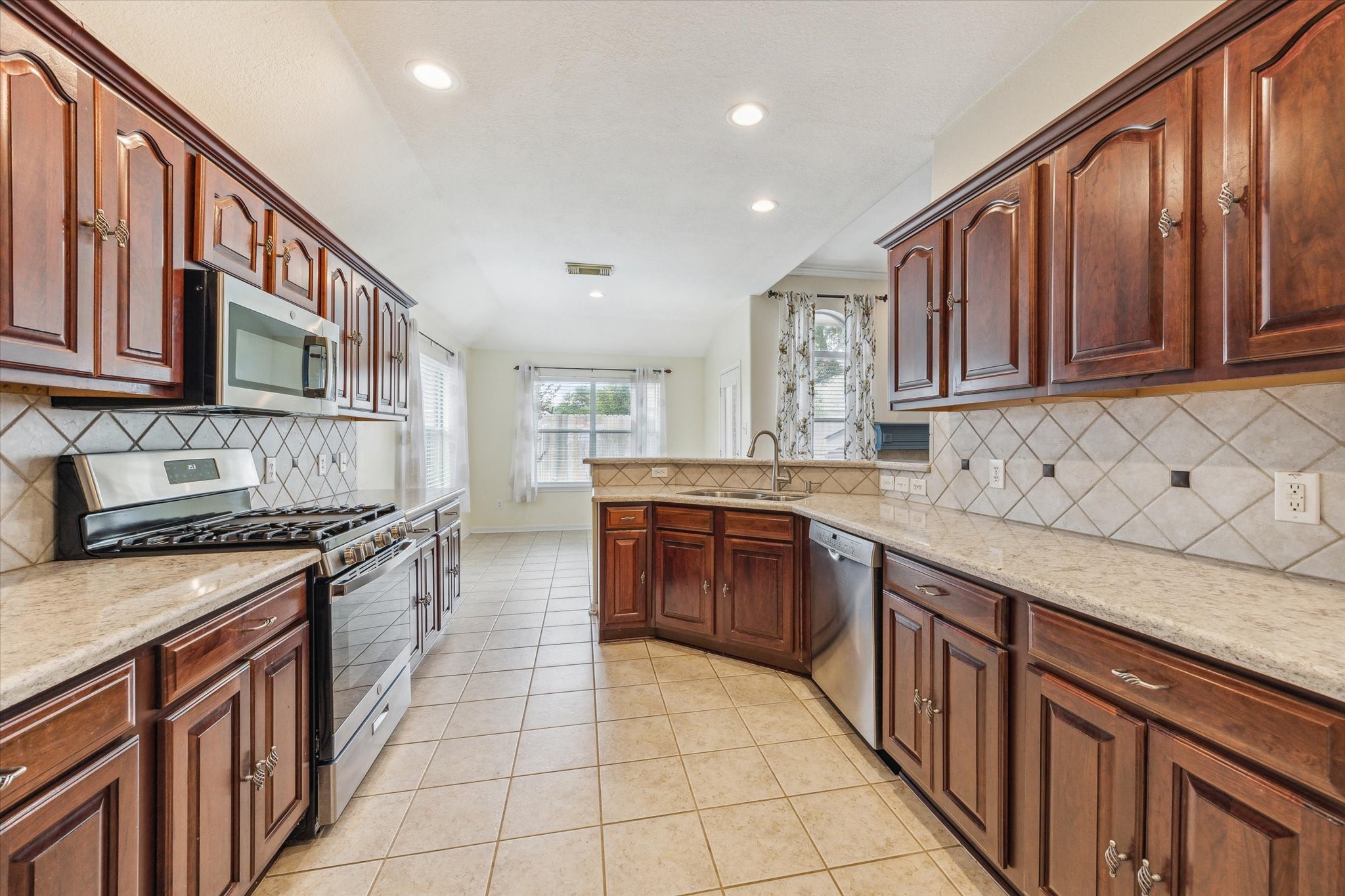5716 Meadow Breeze Lane Rosharon, TX 77583 - Photo 6 of 24 Kichen showing plenty of counter space, lovely wood cabinets, and quartz
countertops and tile floors.