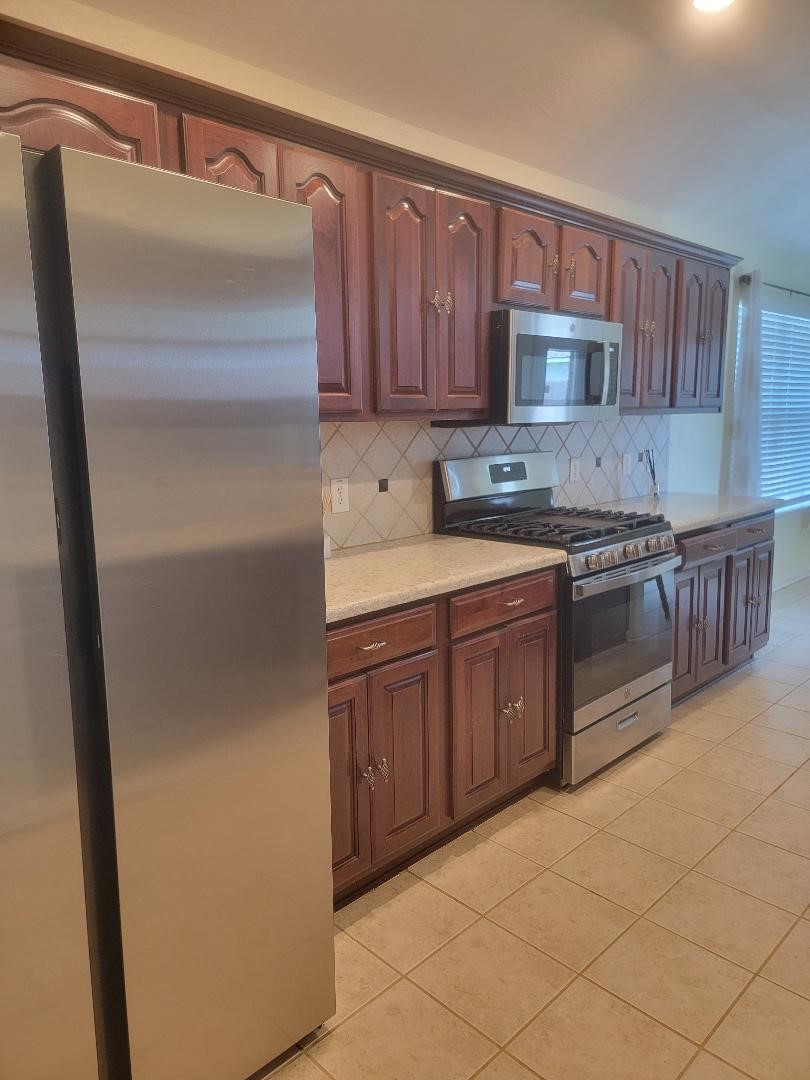 5716 Meadow Breeze Lane Rosharon, TX 77583 - Photo 7 of 24 One side of the kitchen showing the refrigerator included in sale.