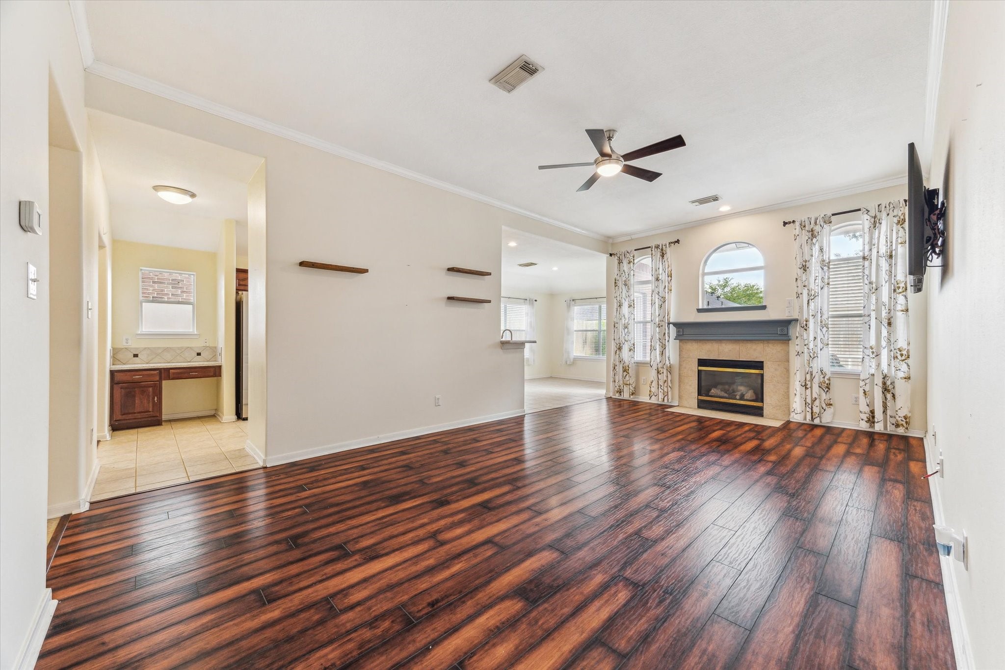 5716 Meadow Breeze Lane Rosharon, TX 77583 - Photo 10 of 24 Family room with beautiful wood floors. Nice fireplace. Also you will see the desk area in the kitchen on the left.