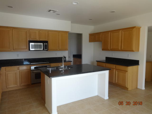 43660 Windrose Place Lancaster, CA 93536 - Photo 4 of 8 a kitchen with stainless steel appliances granite countertop a sink stove and microwave